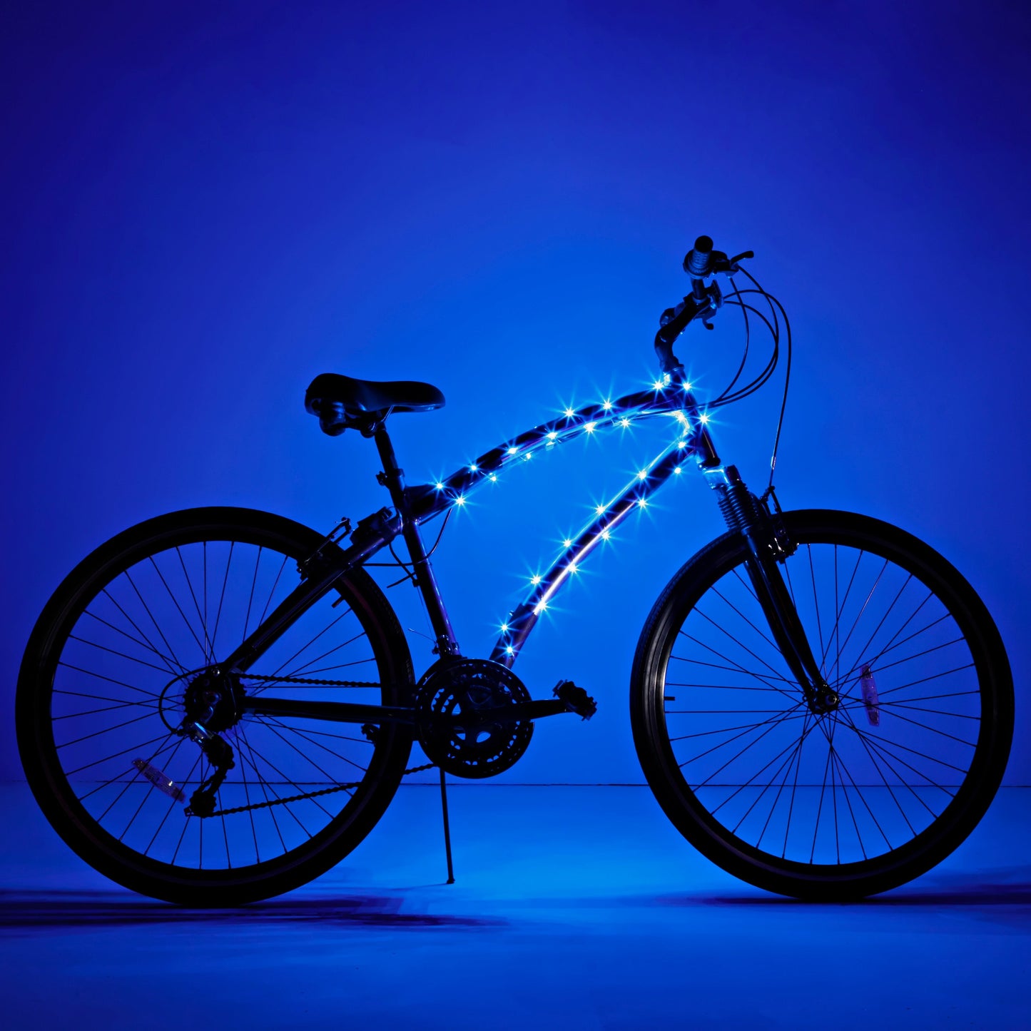 Bicicleta completa con luz LED Brightz en el cuadro encendida sobre fondo azul
