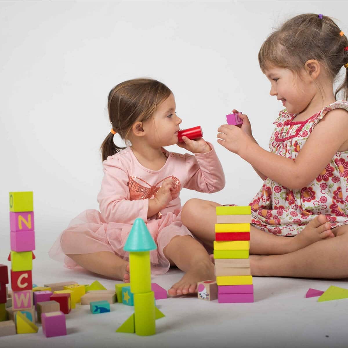 niñas jugando con bloques en madera para primeras construcciones