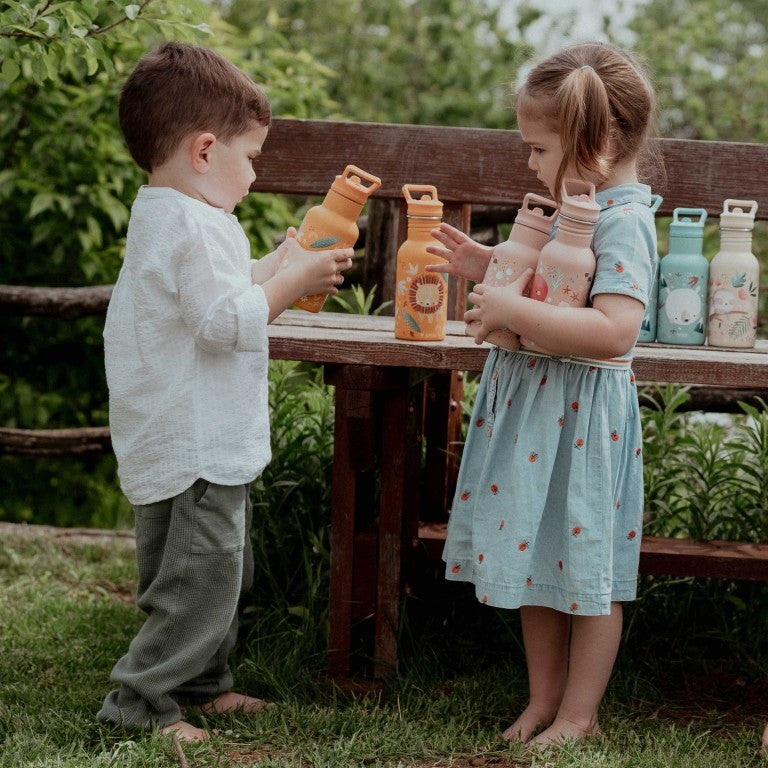 Niños pequeños con las botellas de acero inoxidable de SASSI del pulpo y del león