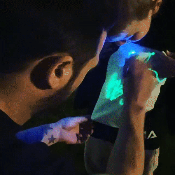 detalle del panel fosforescente de la camiseta negra con brillo verde
