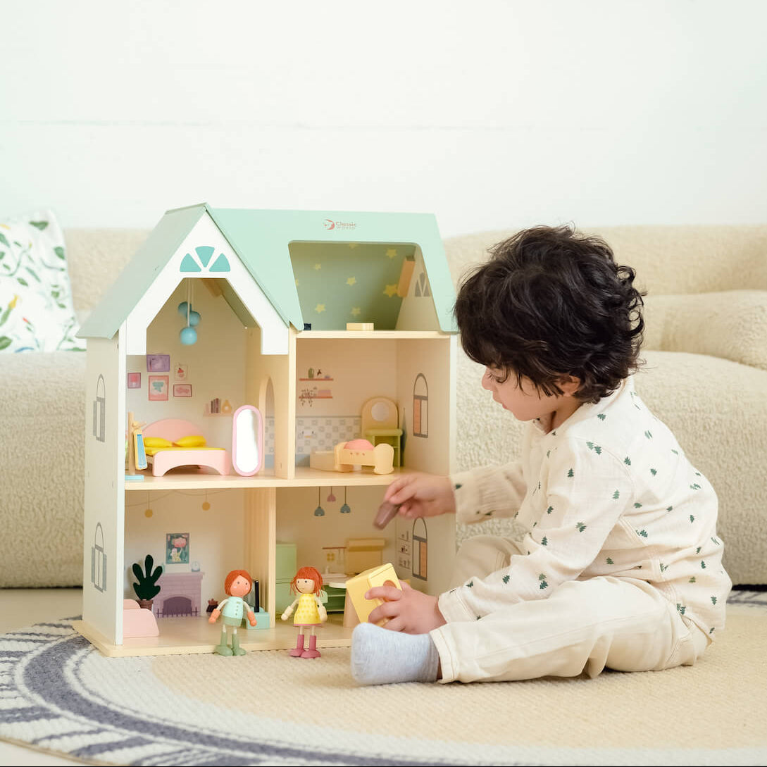 Niño jugando con la Casa de madera para muñecas Cottage de Classic World
