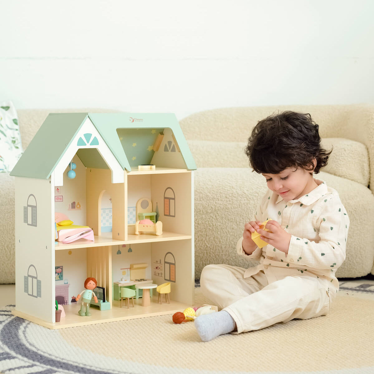 Niño jugando con los muebles de juguete de la Casa de muñecas Cottage de Classic World