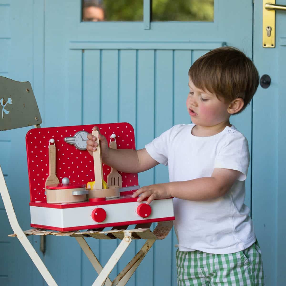 niño cocinando con la cocina de sobremesa retro de madera roja y blanca Classic World 