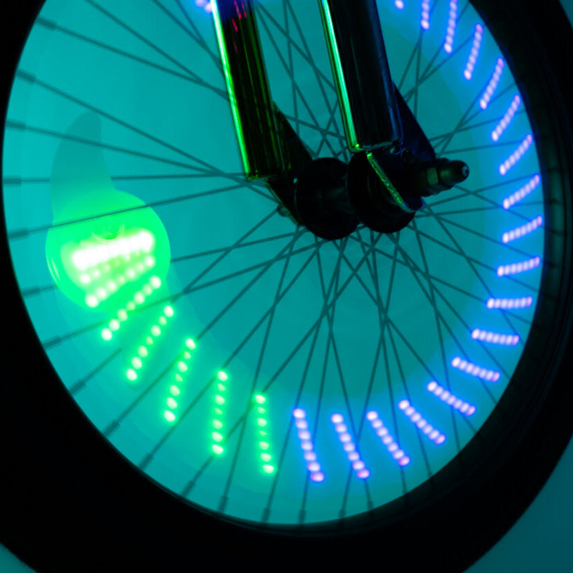 Rueda de bicicleta con formas luminosas Brightz encendidas dibujando un patrón geométrico