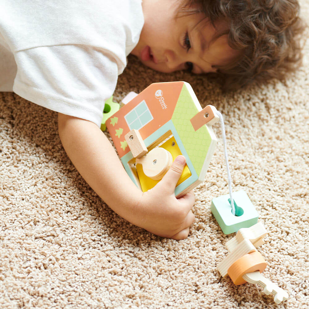 Niño sosteniendo el juego de ensartar formas con cerradura de Classic World para bebés de 18 meses de inspiración Montessori