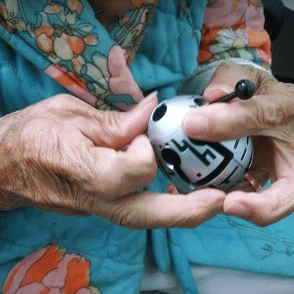 Persona mayor guiando la varita a través del laberinto del huevo Smart Egg