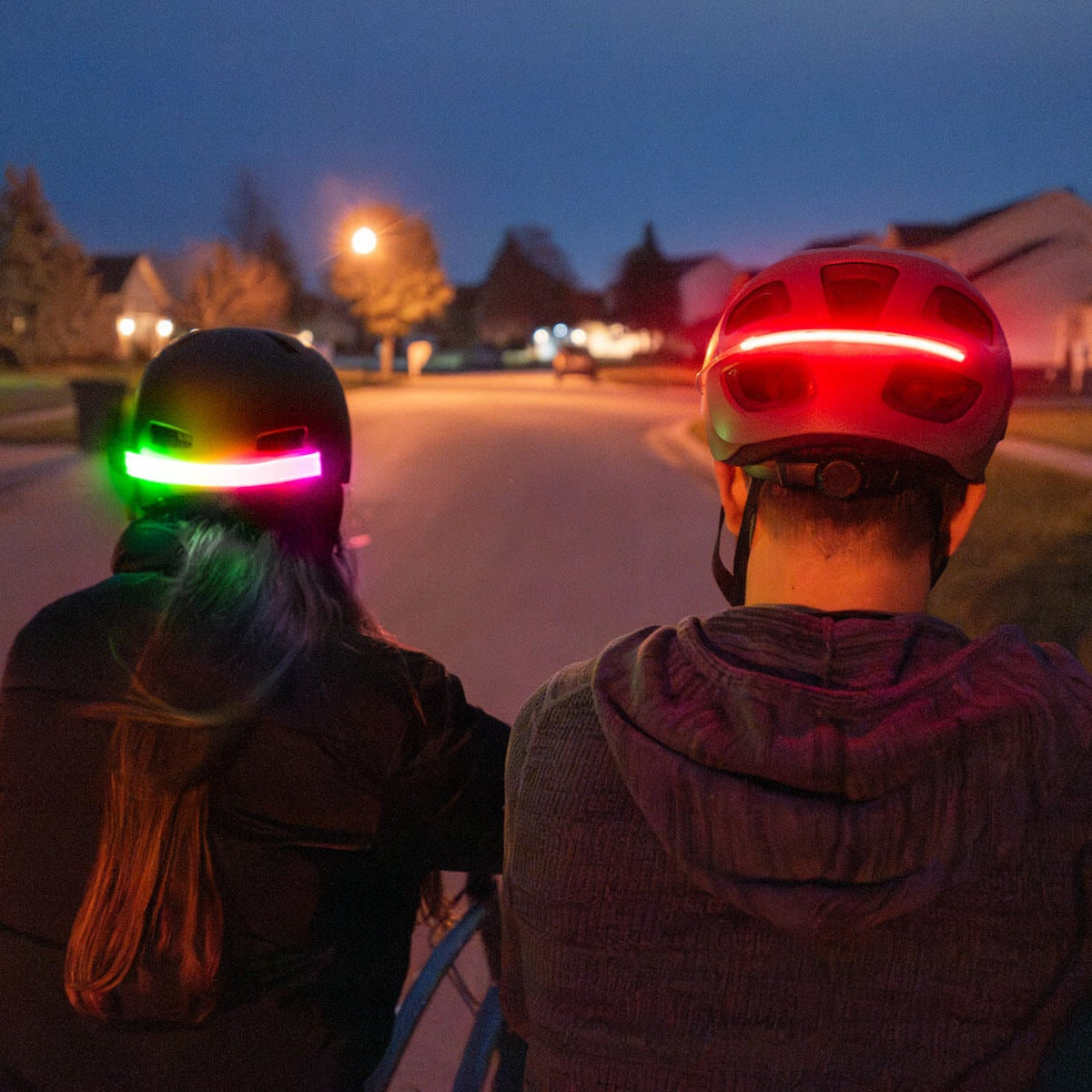 Ciclista con luz multicolor Brightz en el casco encendida de noche 