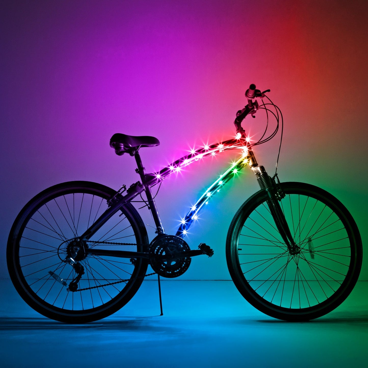 Bicicleta completa con luz LED Brightz en el cuadro encendida sobre fondo de colores