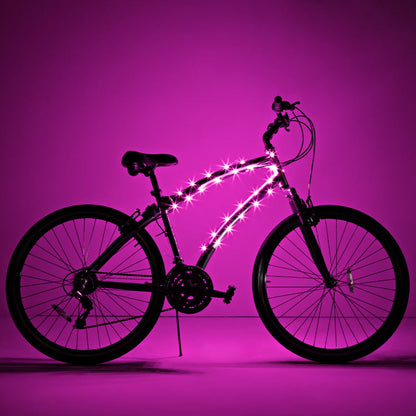 Bicicleta completa con luz LED Brightz en el cuadro encendida sobre fondo rosa