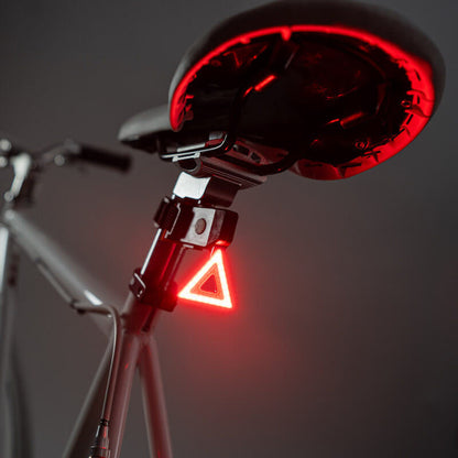 Luz trasera triangular LED Brightz encendida fijada a la tija del sillín de una bicicleta