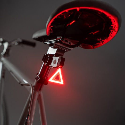 Luz trasera triangular LED Brightz encendida fijada a la tija del sillín de una bicicleta