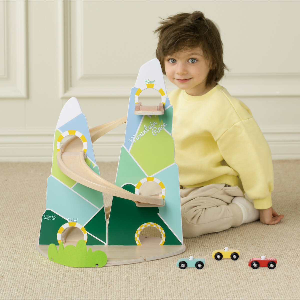 niño jugando con rampa de coches de madera Mountain Race Classic World con tres niveles y tres coches