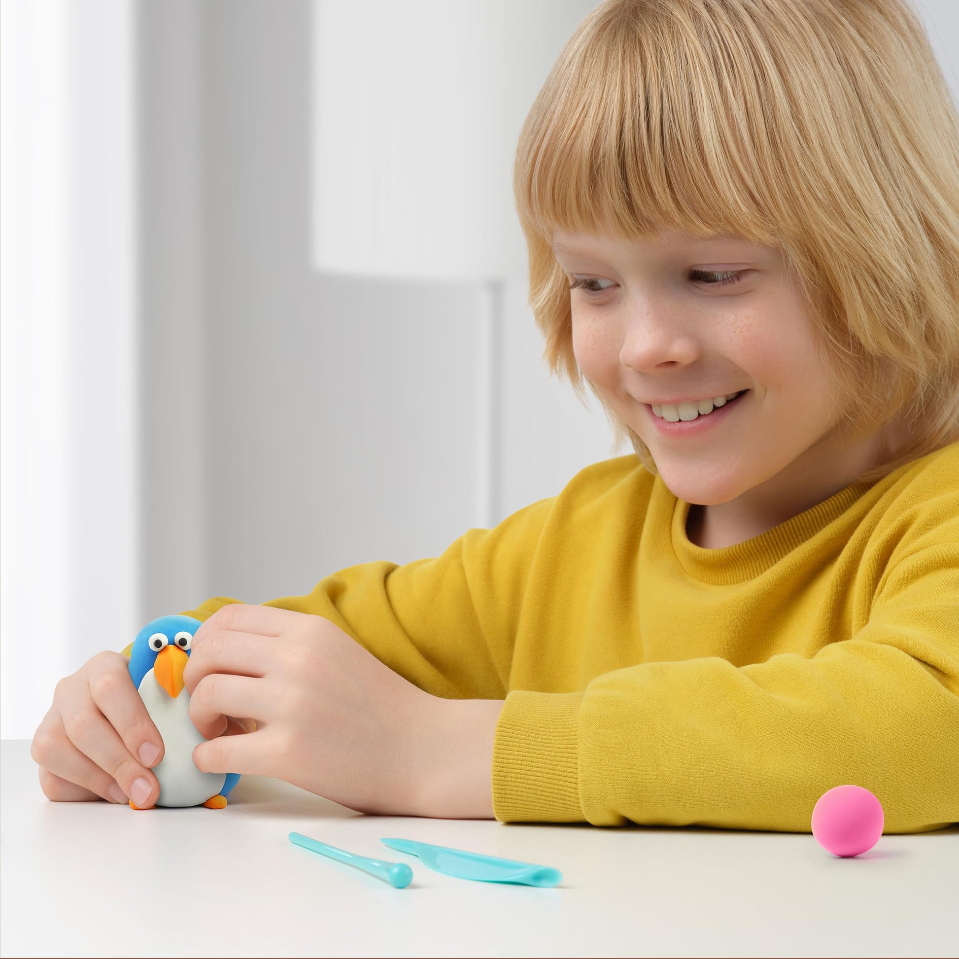 niño jugando con plastilina interactiva pingüino hey clay