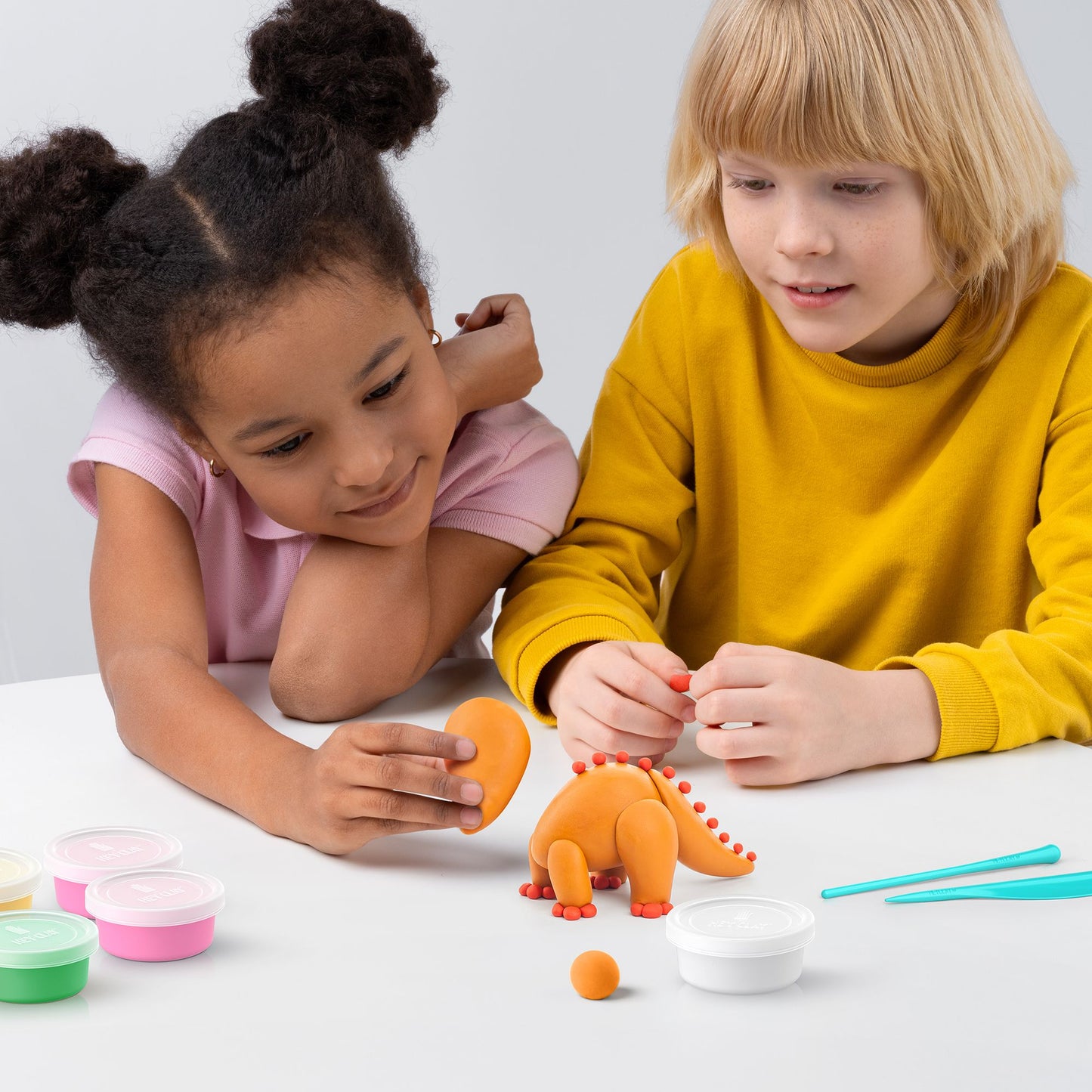 niños modelando plastilina Hey Clay triceratops