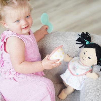 niña jugando a dar de comer a muñeca Love Stella con cuchara y tazón
