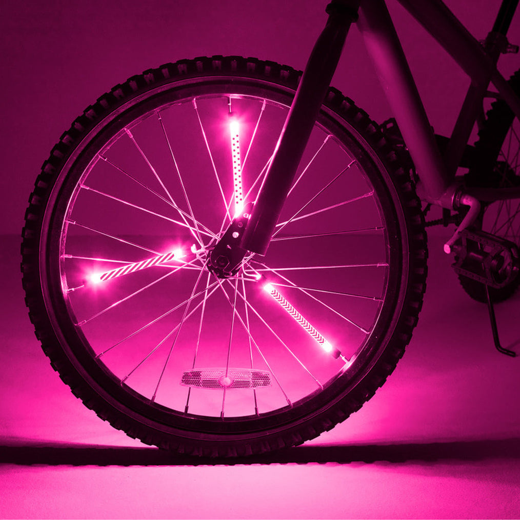 Biciclet con tubos luminosos LED Brightz rosa instalados en los radios de la rueda