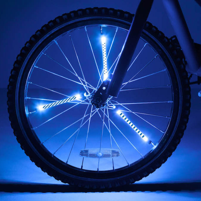 Bicicleta con tubos luminosos Brightz azul instalados en los radios de la rueda