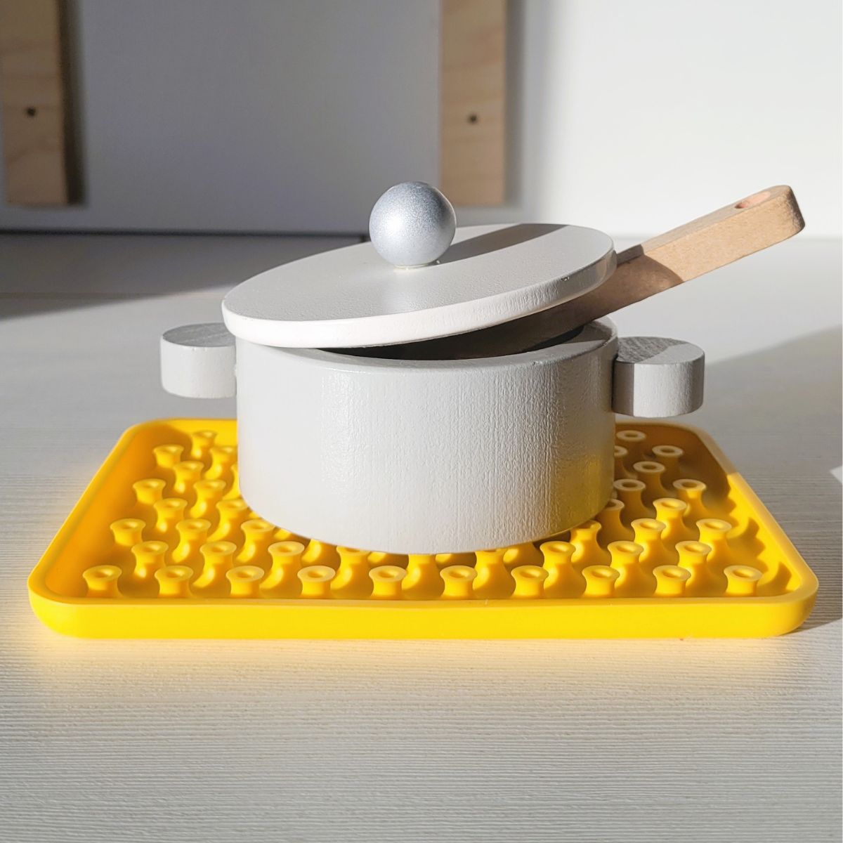 Juego sensorial de silicona Wiggly toy de color amarillo que también sirve como salvamanteles